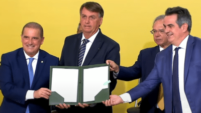 Jair Bolsonaro ao lado de Onyx Lorenzoni e Paulo Guedes durante cerimônia de assinatura da MP do teletrabalho.